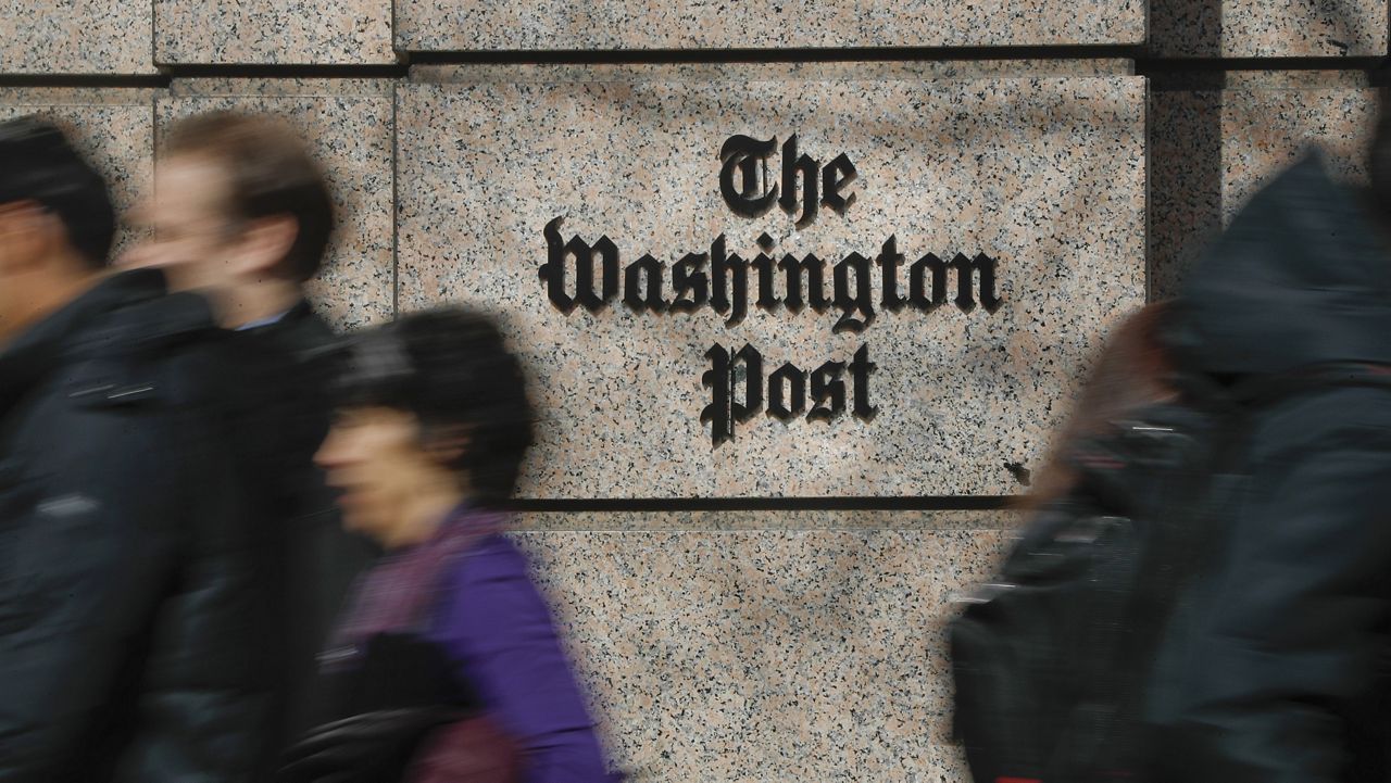 People walk by the One Franklin Square Building, home of The Washington Post newspaper, in downtown Washington, Feb. 21, 2019. (AP Photo/Pablo Martinez Monsivais)