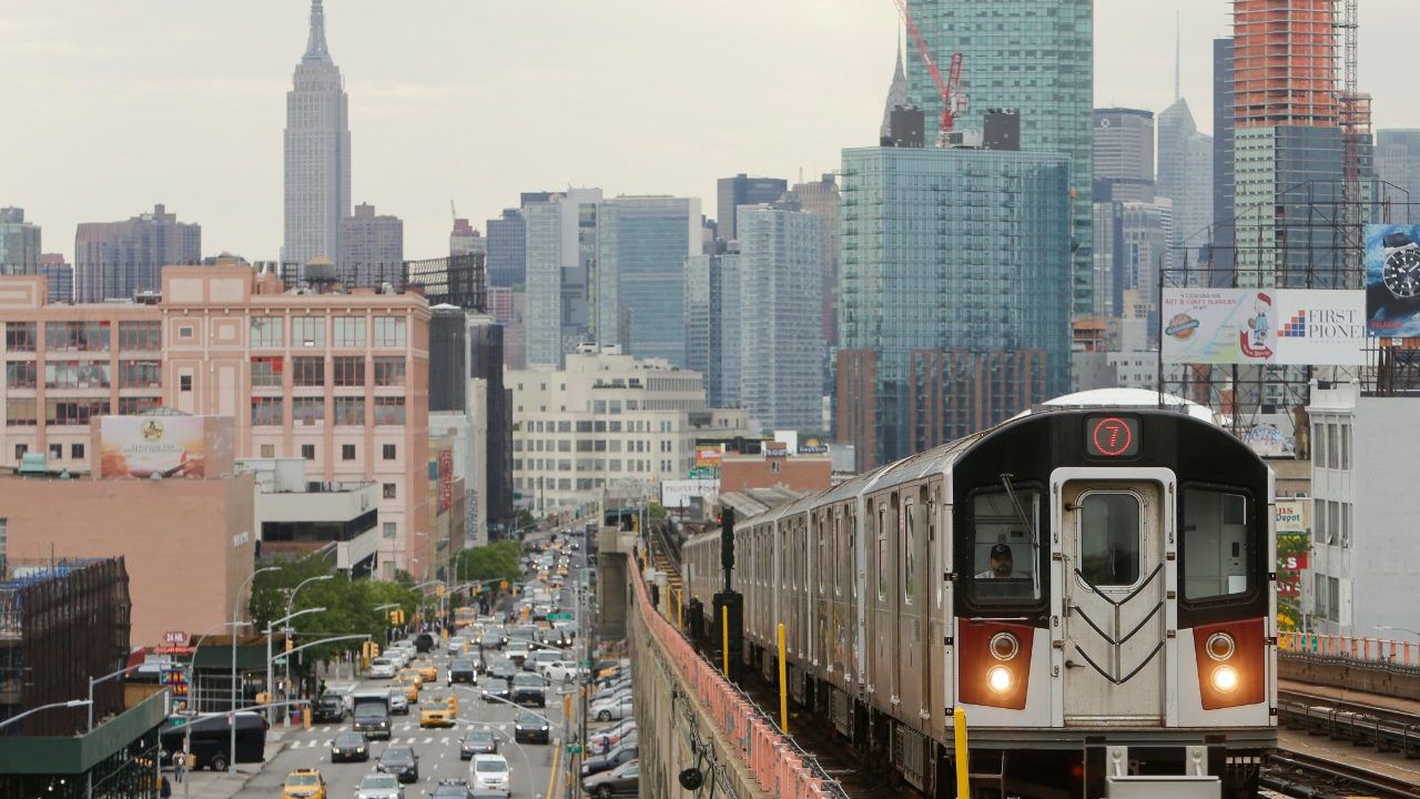 The 7 train and Manhattan skyline are pictured.