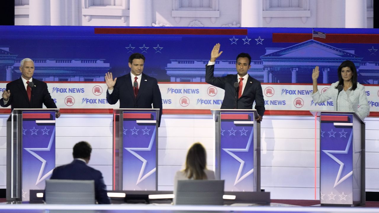 Former Vice President Mike Pence, Florida Gov. Ron DeSantis, businessman Vivek Ramaswamy and former U.N. Ambassador Nikki Haley raise their hands in response to a question if they would support the eventual party nominee during a Republican presidential primary debate hosted by FOX News Channel Wednesday, Aug. 23, 2023, in Milwaukee. (AP Photo/Morry Gash)