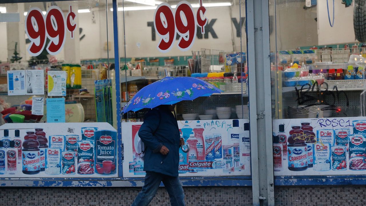 A pedestrian walks past a 99 Cents Only store under light rain in Los Angeles Wednesday, Dec. 5, 2018. (AP Photo/Damian Dovarganes, File)