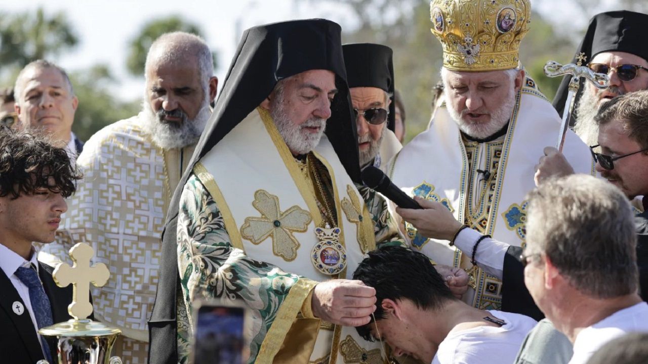 John Hittos receives a necklace from Greek Orthodox Church officials after retrieving the cross during the 2024 Epiphany. (Associated Press photo)