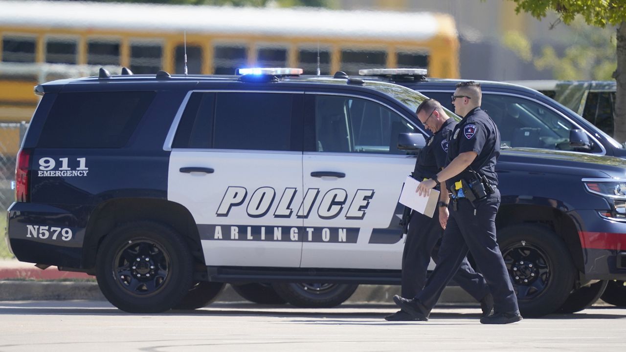 In this Wednesday, Oct. 6, 2021, file photo, law enforcement officers walk in a parking lot.