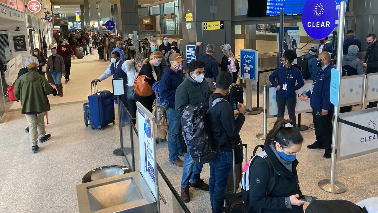 Travelers stand in line at a TSA security checkpoint at Austin-Bergstrom International Airport Friday, Feb. 19, 2021, in Austin, Texas. (AP Photo/Ashley Landis)