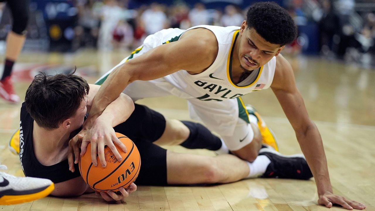 Baylor guard RayJ Dennis, top, tries to steal the ball from Cincinnati guard Simas Lukosius during the first half of an NCAA college basketball game in the quarterfinal round of the Big 12 Conference tournament, Thursday, March 14, 2024, in Kansas City, Mo. (AP Photo/Charlie Riedel)