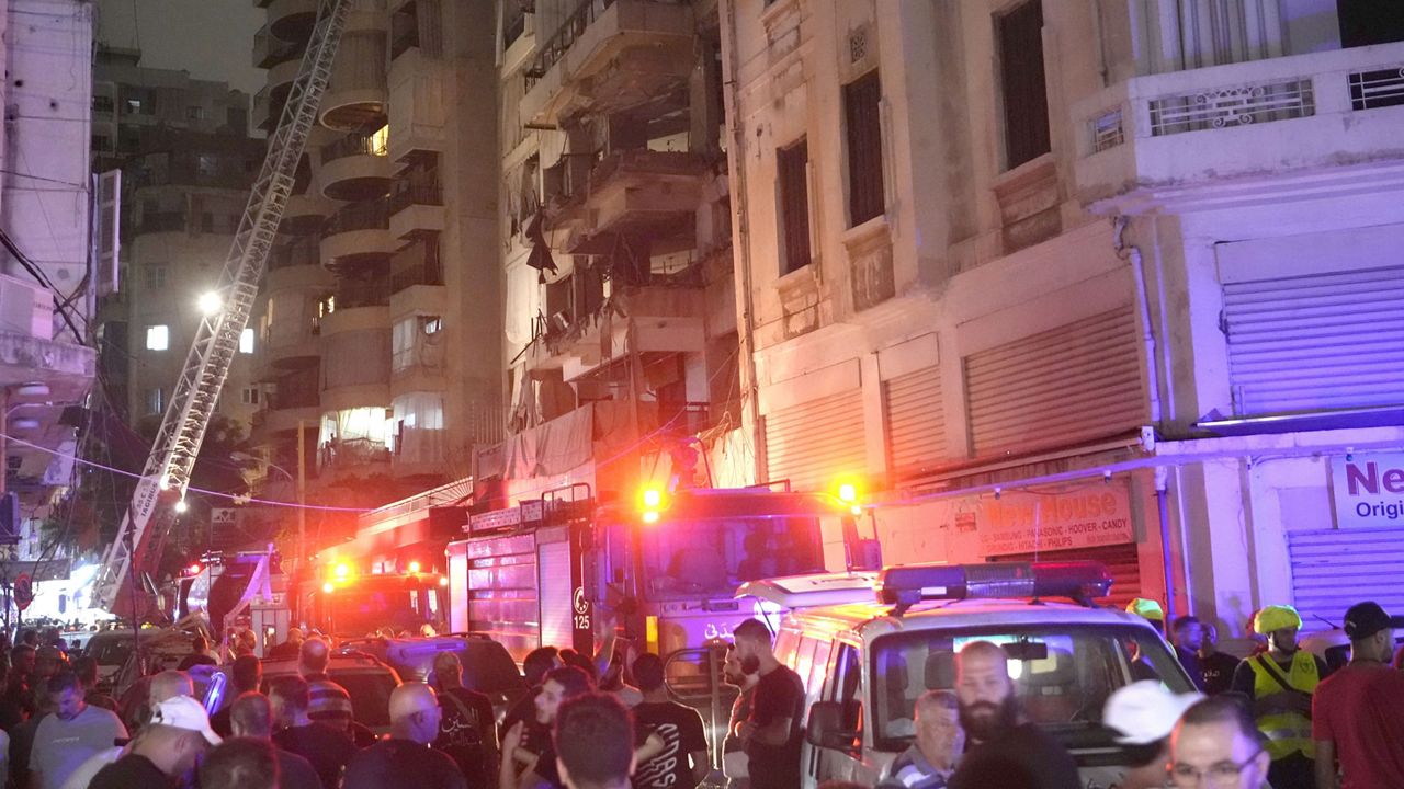 Rescue workers on a crane check a destroyed building hit by an Israeli airstrike in central Beirut, Lebanon, Thursday, Oct. 10, 2024. (AP Photo/Hassan Ammar)