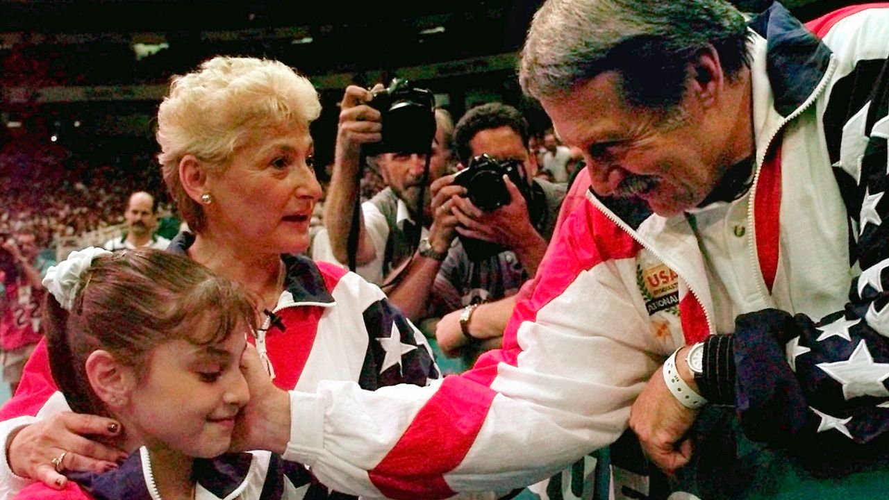 Bela Karolyi, right, congratulates Dominique Moceanu, left, after the United States captured the gold medal in the women's team gymnastics competition at the Centennial Summer Olympic Games in Atlanta, July 23, 1996. (AP Photo/Amy Sancetta, File)