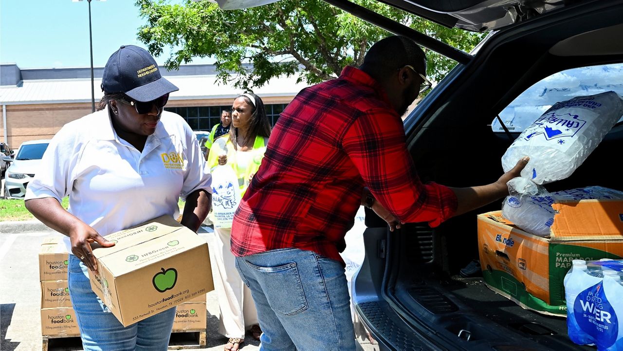 Volunteers help to hand out ice and supplies at Acres Homes cooling center in Houston, Wednesday, July 10, 2024. After Hurricane Beryl slammed into Texas, knocking out power to nearly 3 million homes and businesses. (AP Photo/Maria Lysaker)