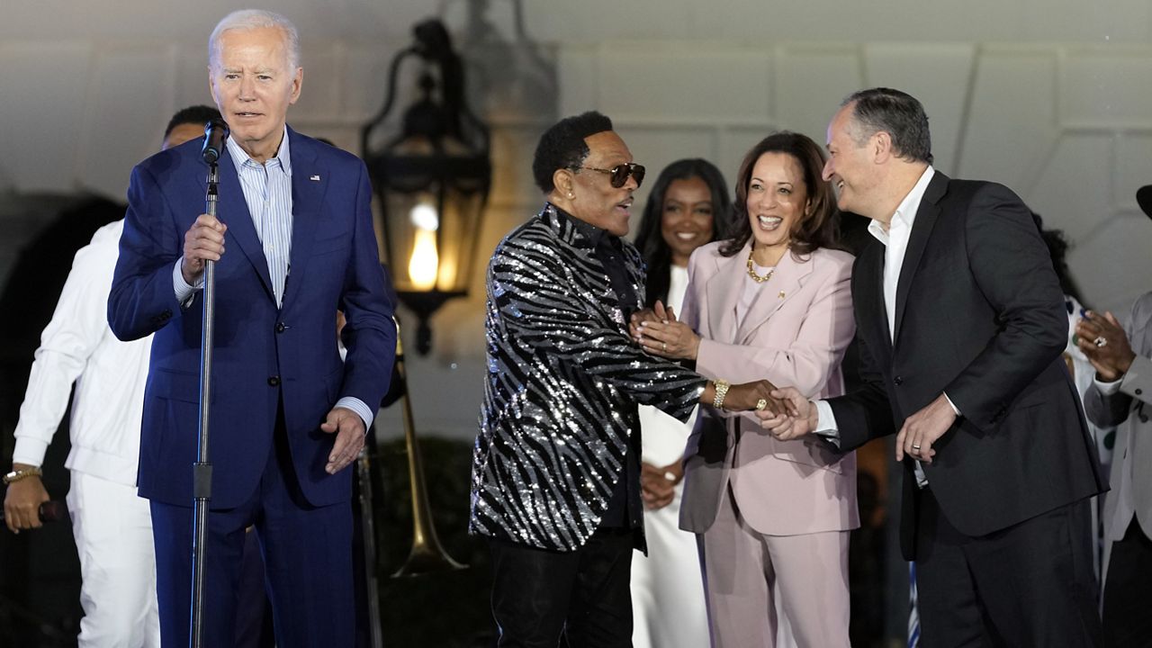 President Joe Biden says goodnight as singer and songwriter Charlie Wilson talks with Vice President Kamala Harris and second gentleman Doug Emhoff during a Juneteenth concert on the South Lawn of the White House in Washington, Monday, June 10, 2024. (AP Photo/Susan Walsh)