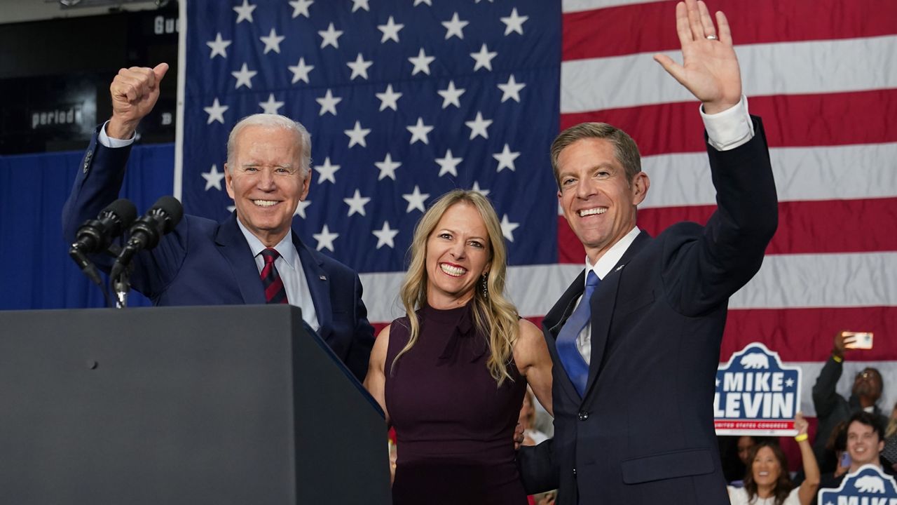 President Joe Biden stands on stage with Rep. Mike Levin, D-Calif., and his wife Chrissy, after Biden spoke at a campaign rally Thursday, Nov. 3, 2022, in San Diego. (AP Photo/Patrick Semansky)