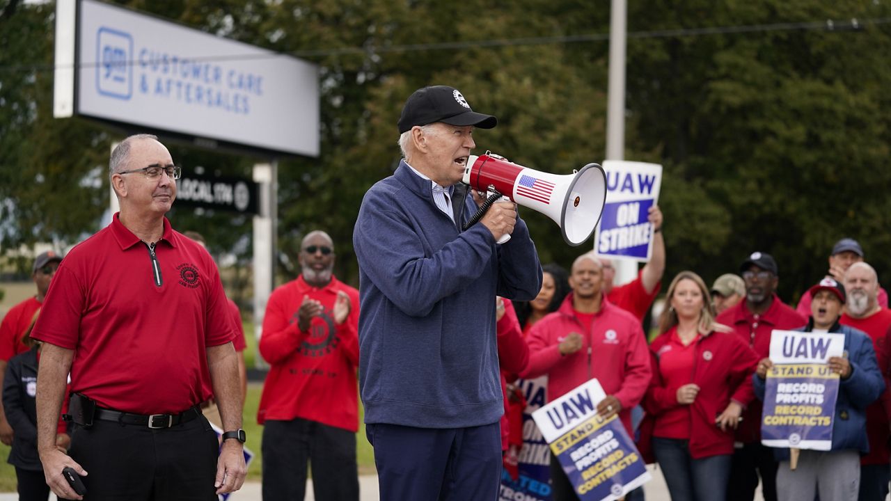 President Joe Biden joins striking United Auto Workers on the picket line, in Van Buren Township, Mich. United Auto Workers President Shawn Fain stands at left. (AP Photo/Evan Vucci)