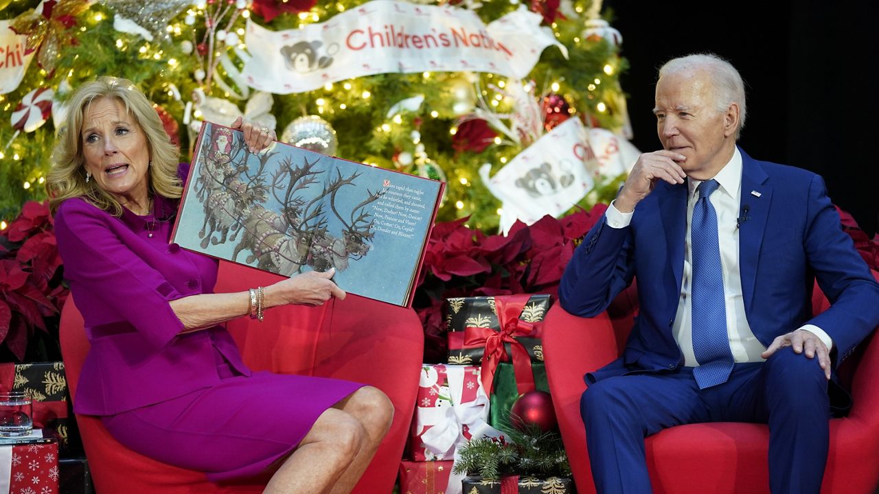 First lady Jill Biden, accompanied by President Joe Biden, reads "Twas the Night Before Christmas" at Children's National Hospital, Friday, Dec. 22, 2023, in Washington. (AP Photo/Evan Vucci)