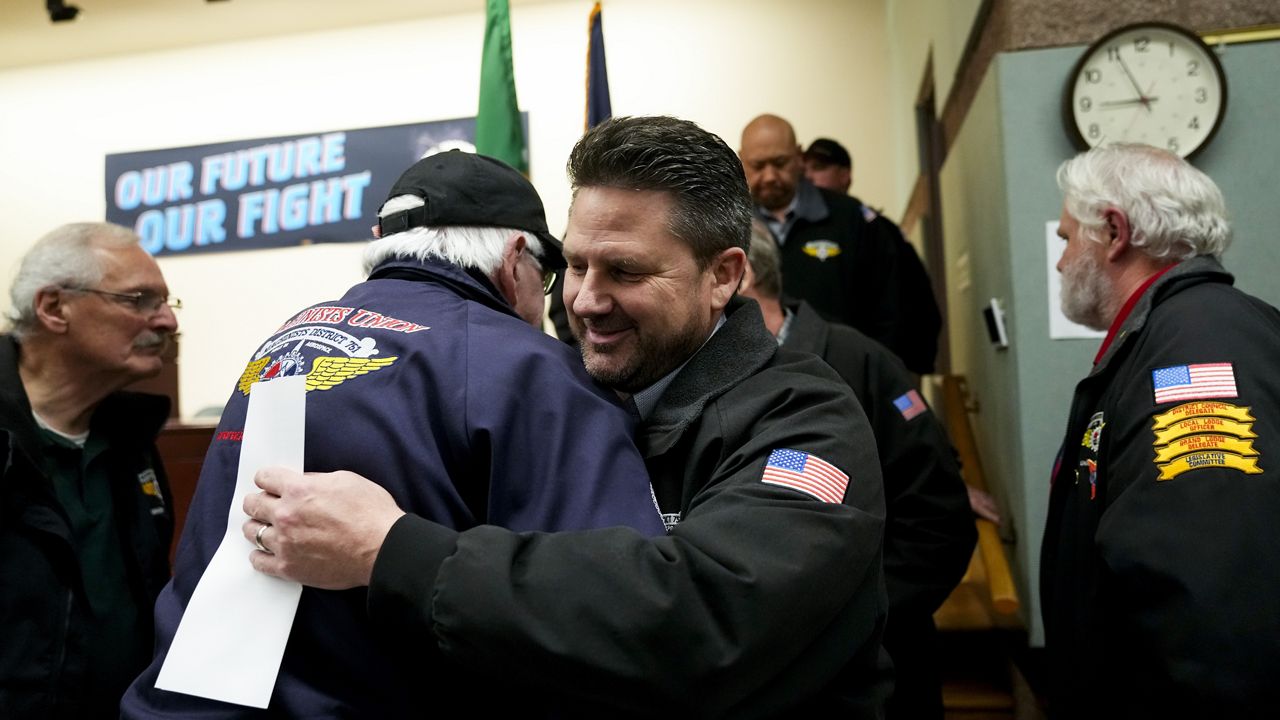 IAM District 751 president Jon Holden greets union members after announcing they voted to accept a new contract offer from Boeing, Monday, Nov. 4, 2024, at their union hall in Seattle. (AP Photo/Lindsey Wasson)