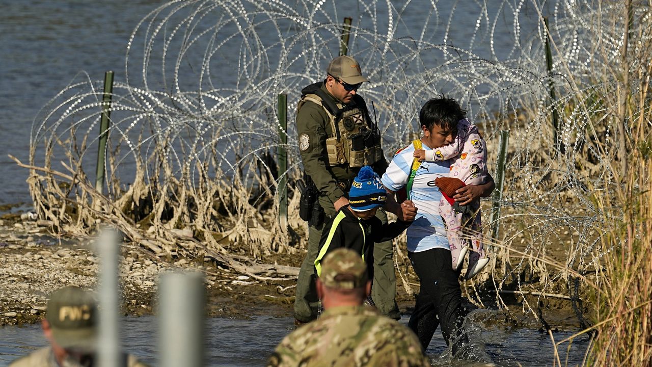 Migrants are taken into custody by officials at the Texas-Mexico border, Wednesday, Jan. 3, 2024, in Eagle Pass, Texas. (AP Photo/Eric Gay)