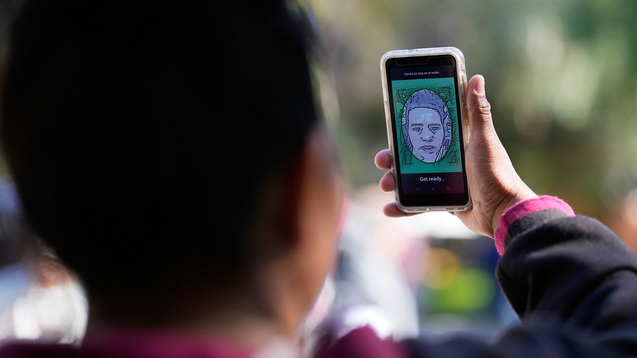 A migrant from Michoacan, Mexico, uses the CBP One app Tuesday, Jan. 24, 2023, in Tijuana, Mexico. (AP Photo/Gregory Bull, File)