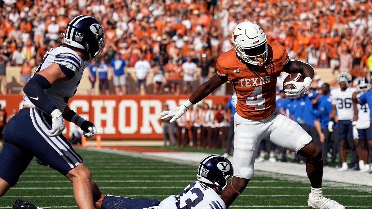 Texas running back CJ Baxter (4) tries to side step BYU safety Raider Damuni (33) during the first half of an NCAA college football game in Austin, Texas, Saturday, Oct. 28, 2023. (AP Photo/Eric Gay)