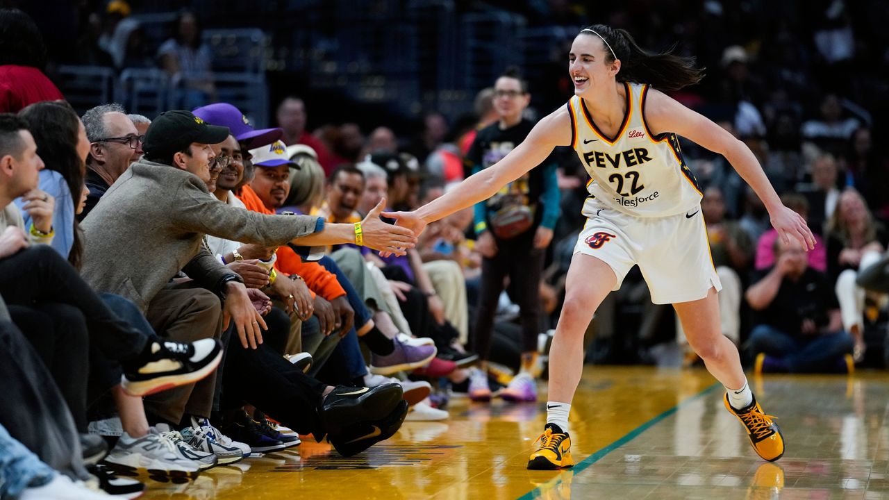 Indiana Fever guard Caitlin Clark (22) greets Ashton Kutcher after making a 3-pointer during the second half of a WNBA basketball game against the Los Angeles Sparks in Los Angeles, Friday, May 24, 2024. (AP Photo/Ashley Landis)