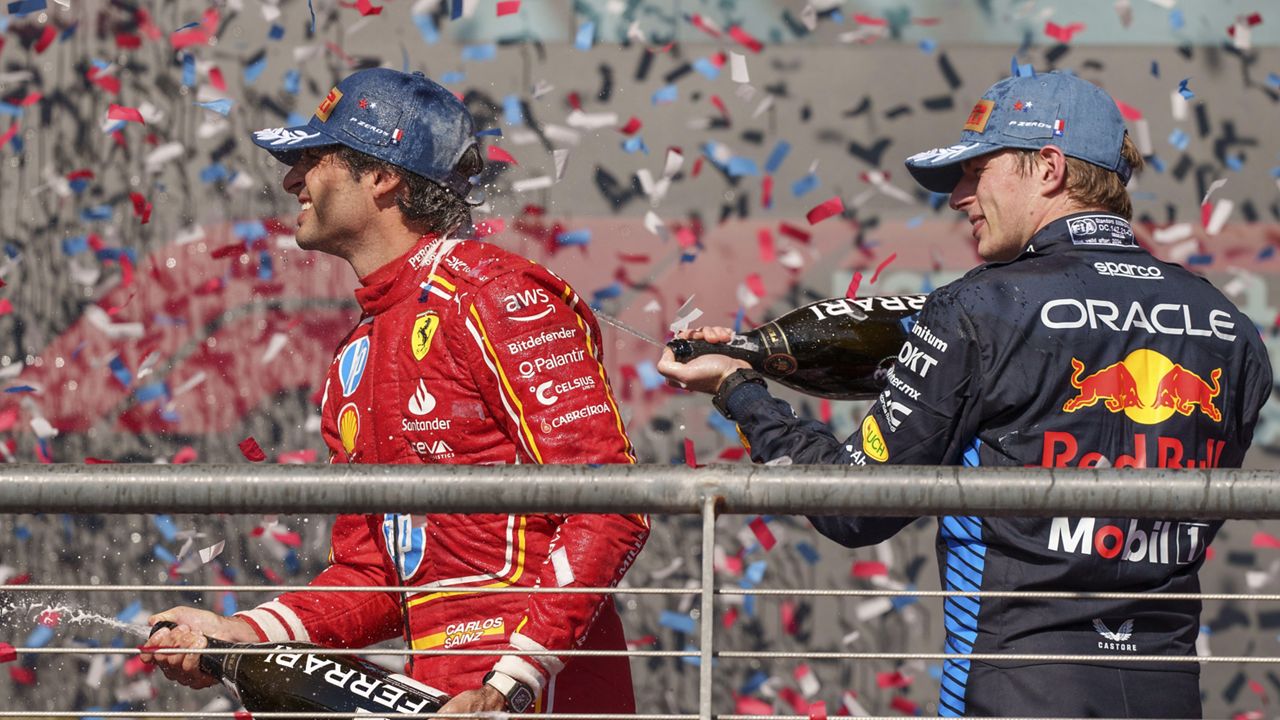 Ferrari driver Carlos Sainz, of Spain, left, and Red Bull driver Max Verstappen, right, of the Netherlands, celebrate after they finished second and third respectively behind winner Charles Leclerc in the Formula One U.S. Grand Prix auto race at Circuit of the Americas, Sunday, Oct. 20, 2024, in Austin, Texas. (AP Photo/Nick Didlick)