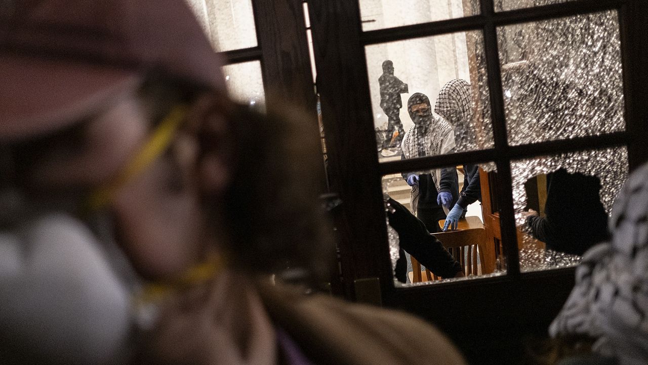 Students with the Gaza solidarity encampment block the entrance of Hamilton Hall at Columbia University after taking over it on Tuesday, April 30, 2024 in New York. (Marco Postigo Storel via AP)