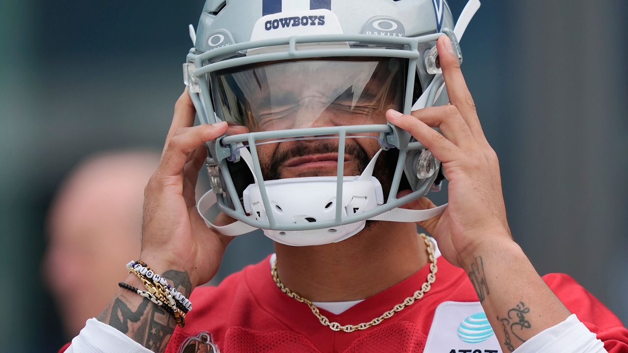 Dallas Cowboys quarterback Dak Prescott puts on his helmet before an NFL football team practice in Frisco, Texas, Wednesday, May 22, 2024. (AP Photo/LM Otero)