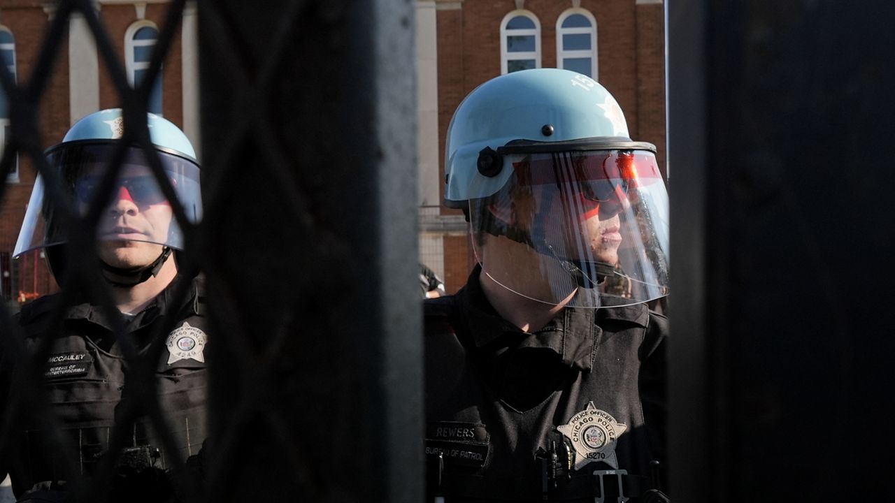 Police stand near where protesters knocked down a fence surrounding United Center at the Democratic National Convention after a march Monday, Aug. 19, 2024, in Chicago. (AP Photo/Frank Franklin II)