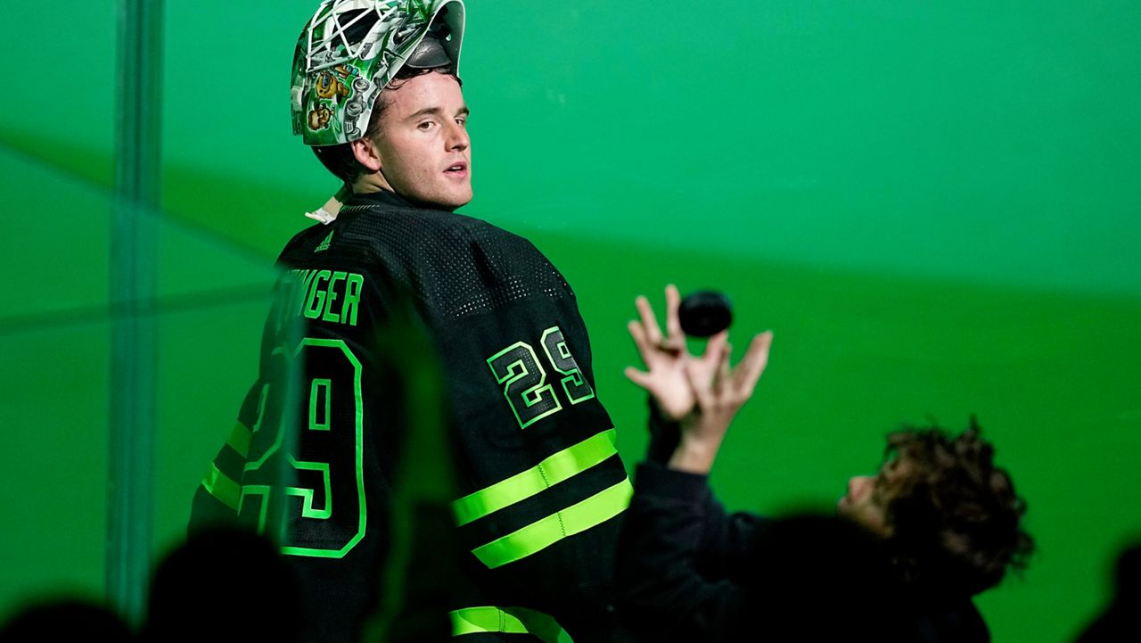 Dallas Stars goaltender Jake Oettinger watches a young fan catch a puck Oettinger had tossed over the glass as the team celebrated a win over the Edmonton Oilers in an NHL hockey game Wednesday, April 3, 2024, in Dallas. (AP Photo/Tony Gutierrez)