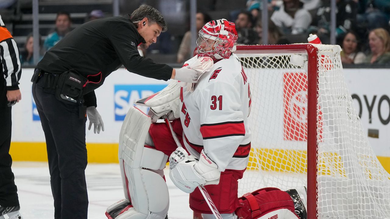 Carolina Hurricanes goaltender Frederik Andersen (31) is checked on by a trainer during the first period of an NHL hockey game against the San Jose Sharks in San Jose, Calif., Tuesday, Oct. 17, 2023. (AP Photo/Jeff Chiu)