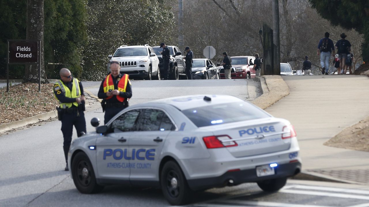 Athens-Clarke County police block traffic and investigate at the UGA intramural Fields after the body of a women was found with found with visible injuries was found in the woods around Lake Herrick in Athens, Ga., on Thursday, Feb. 22, 2024. (Joshua L. Jones/Athens Banner-Herald via AP)