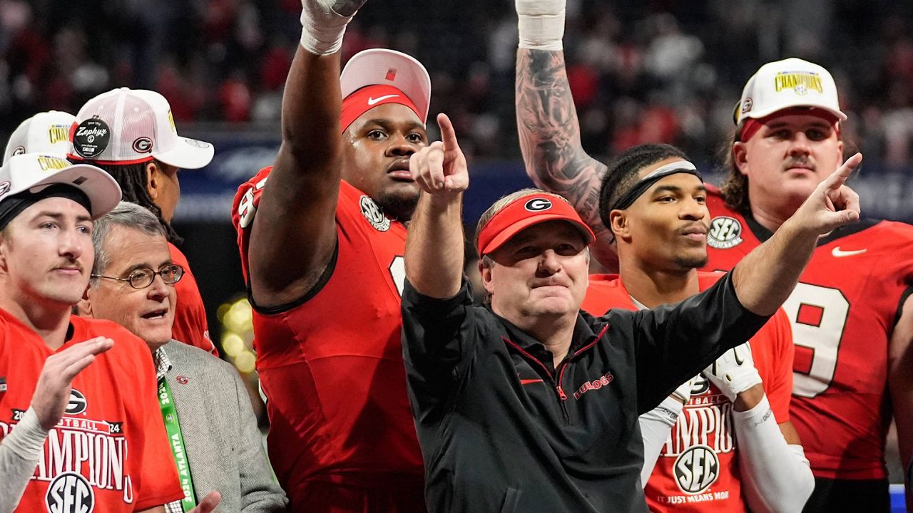 Georgia head coach Kirby Smart and players celebrate a win over Texas after the Southeastern Conference championship NCAA college football game, Saturday, Dec. 7, 2024, in Atlanta. (AP Photo/John Bazemore)