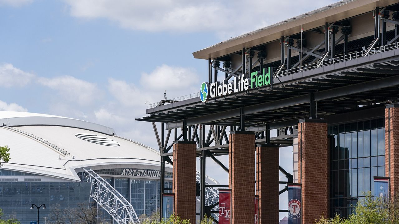 The facade of Globe Life Field stands in front of the Dallas Cowboys' AT&T Stadium before a baseball game between the Texas Rangers and the Toronto Blue Jays Monday, April 5, 2021, in Arlington, Texas. (AP Photo/Jeffrey McWhorter)