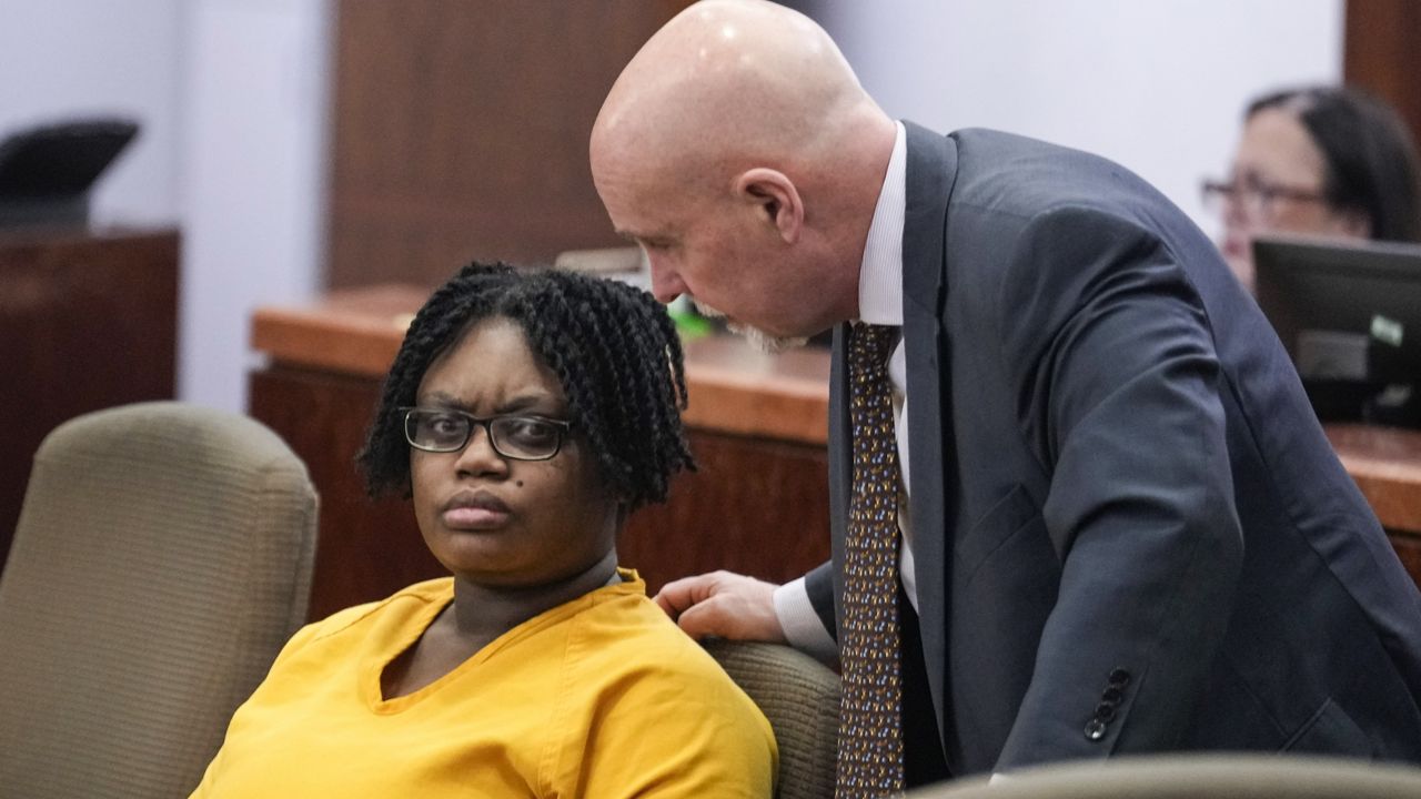 Defendant Gloria Williams, charged in connection with the death of her 8-year-old son, whose skeletal remains decomposed for months inside a Houston-area apartment with three surviving but abandoned siblings, listens to one of her lawyers Neal Davis III, during a hearing Tuesday, Nov. 12, 2024, at the Harris County Criminal Justice Center in Houston. (Brett Coomer/Houston Chronicle via AP)