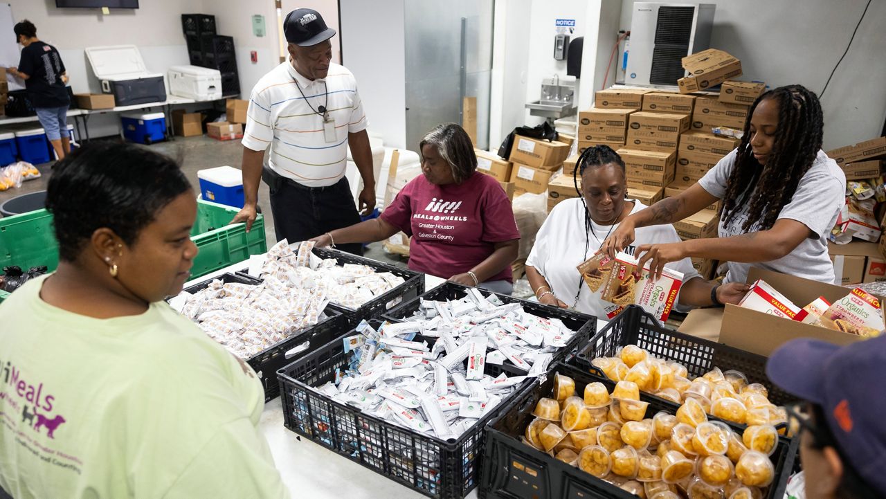 Meals on Wheels employees take advantage of an assembly line to prepare bags of food for clients, Friday, July 12, 2024, in Houston. Staff deliver hot meals as well as shelf stable items to clients daily, many of whom are still without power after Hurricane Beryl. (AP Photo/Annie Mulligan)