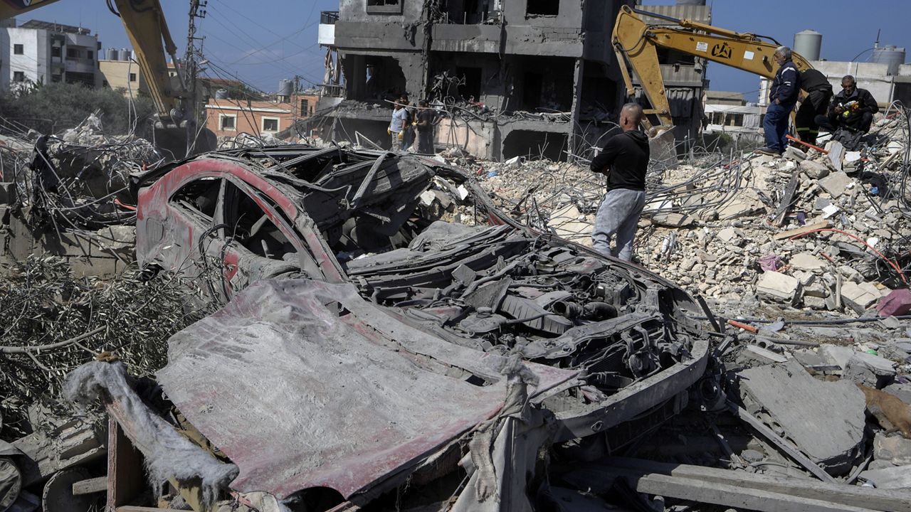 Rescue workers use excavators to remove the rubble of a destroyed building that was hit Tuesday night in an Israeli airstrike, as they search for victims in Sarafand, south Lebanon, Wednesday, Oct. 30, 2024. (AP Photo/Bilal Hussein