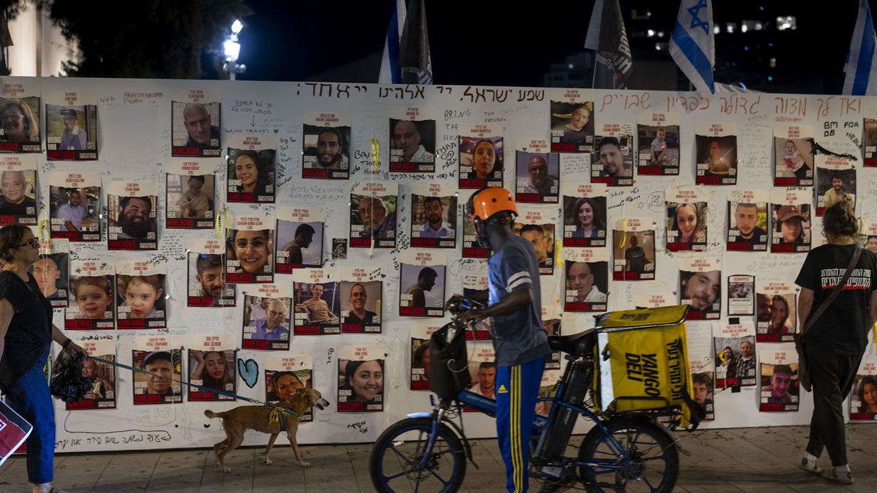 People look at a memorial for the more than 220 people captured by Hamas militants, in Tel Aviv, Israel, Saturday, Oct. 28, 2023. (AP Photo/Bernat Armangue)