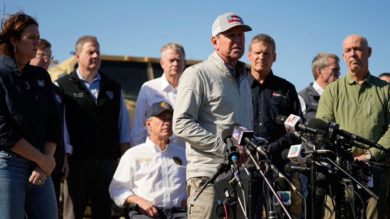 Texas Gov. Greg Abbott, seated center, listens as Georgia Gov. Brian Kemp, center, speaks during a news conference along the Rio Grande to discuss Operation Lone Star and border concerns, Sunday, Feb. 4, 2024, in Eagle Pass, Texas. (AP Photo/Eric Gay)