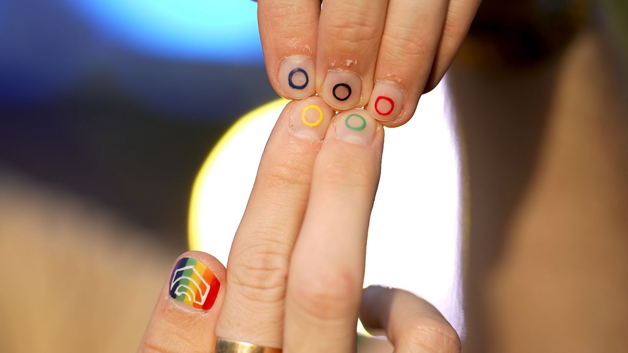 Jeremy Goupille shows his nails painted with the rainbow colors and the Olympic rings at the opening of Pride House, the safe space for the LGBT+ community of athletes, during the 2024 Summer Olympics, Monday, July 29, 2024, in Paris, France. (AP Photo/Natacha Pisarenko)