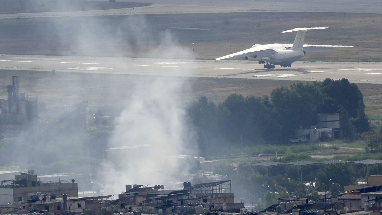 A plane take off from Rafik Hariri international airport as smoke of a past Israeli airstrike still rise from Dahiyeh, in Beirut, Lebanon, Monday, Oct. 14, 2024. (AP Photo/Hussein Malla)