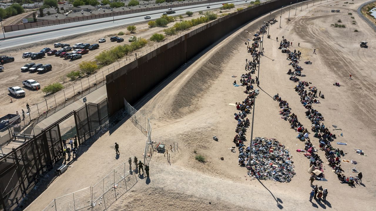 Migrants form lines outside the border fence waiting for transportation to a U.S. Border Patrol facility in El Paso, Texas, May 10, 2023. (AP Photo/Andres Leighton
