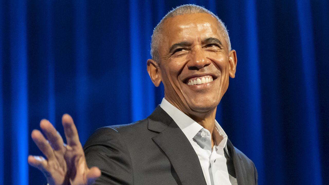 barack obama smiles and waves from stage