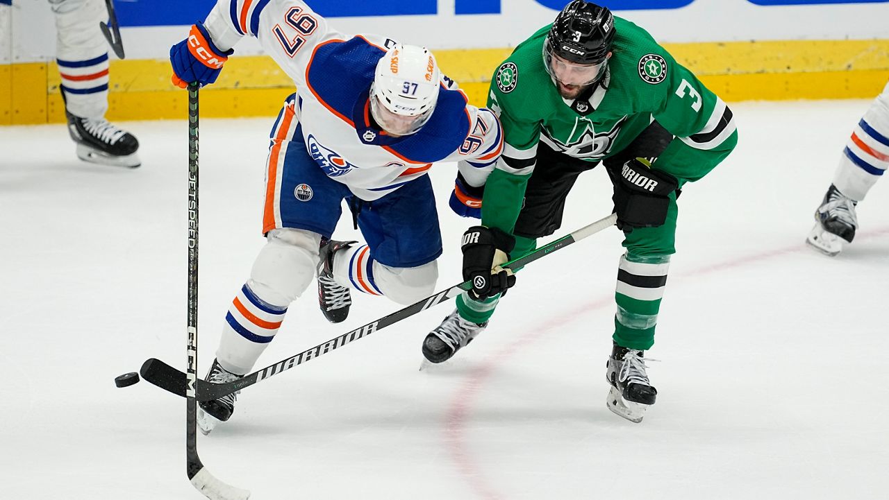 Edmonton Oilers center Connor McDavid (97) competes for the puck agains Dallas Stars defenseman Chris Tanev (3) during the third period in Game 1 of the NHL hockey Western Conference Stanley Cup playoff finals, Thursday, May 23, 2024, in Dallas. (AP Photo/Tony Gutierrez)