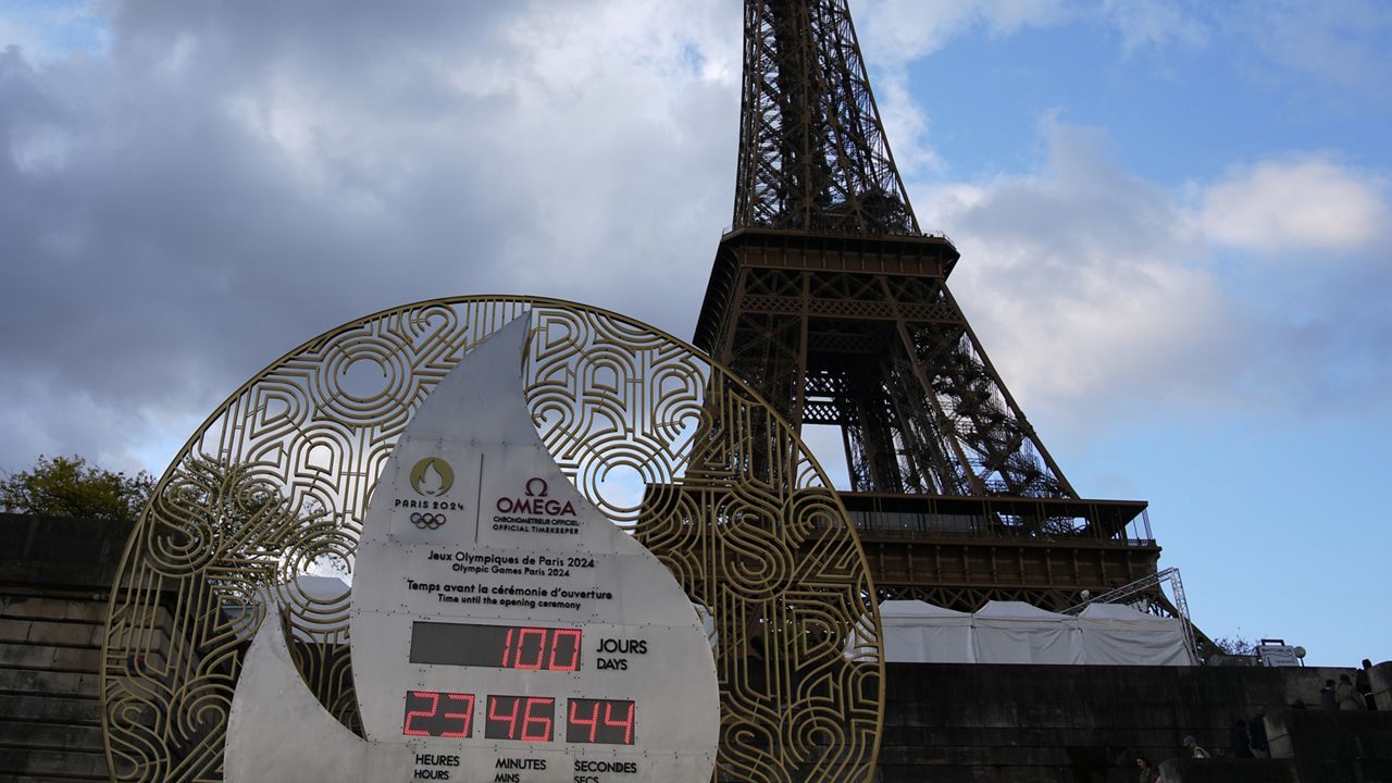 The countdown clock, set up on the banks of the Seine river and in front of the Eiffel Tower, reads 100 days before the Paris 2024 Olympic Games opening ceremony,Tuesday, April 16, 2024 in Paris. (AP Photo/Christophe Ena)