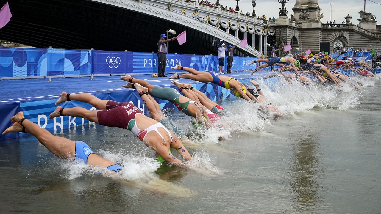 Athletes dive into the water for the start of the women's individual triathlon competition at the 2024 Summer Olympics, Wednesday, July 31, 2024, in Paris, France. (AP Photo/Vadim Ghirda)