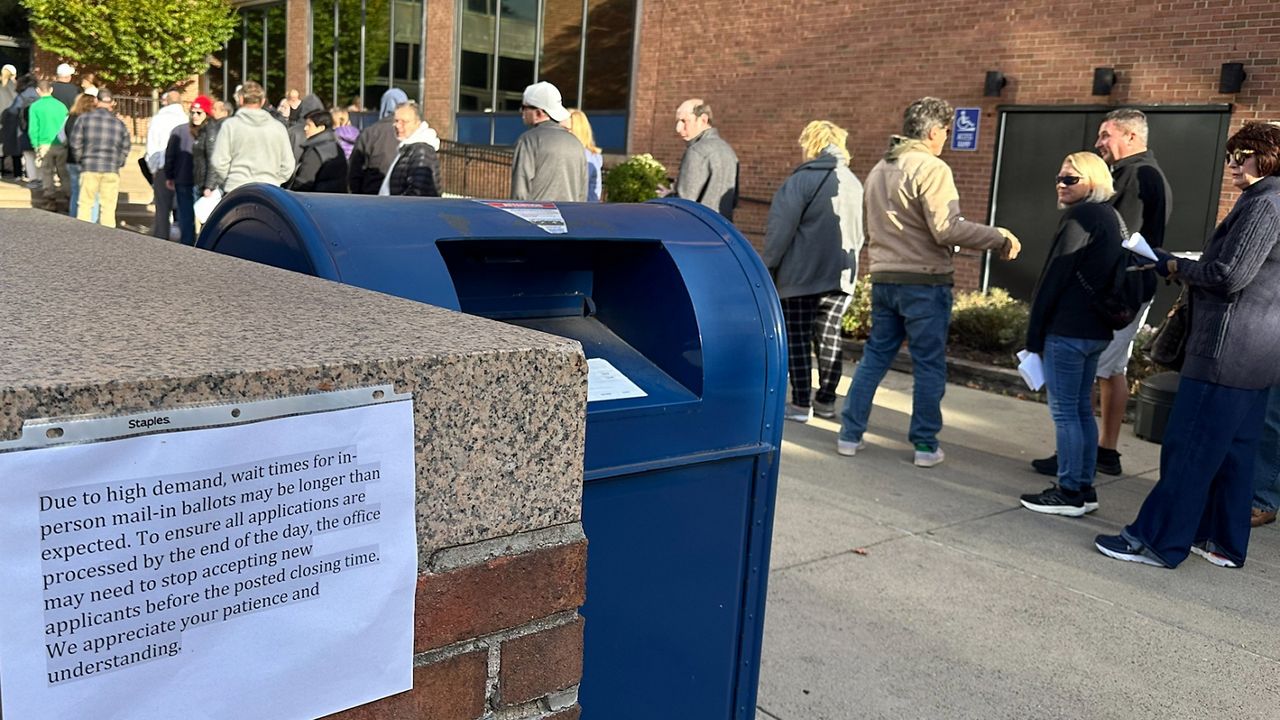 People wait in line outside the Bucks County government building to apply for an on-demand mail ballot on the last day to request one in Doylestown, Pa., Tuesday, Oct. 29, 2024. (AP Photo/Mike Catalini)