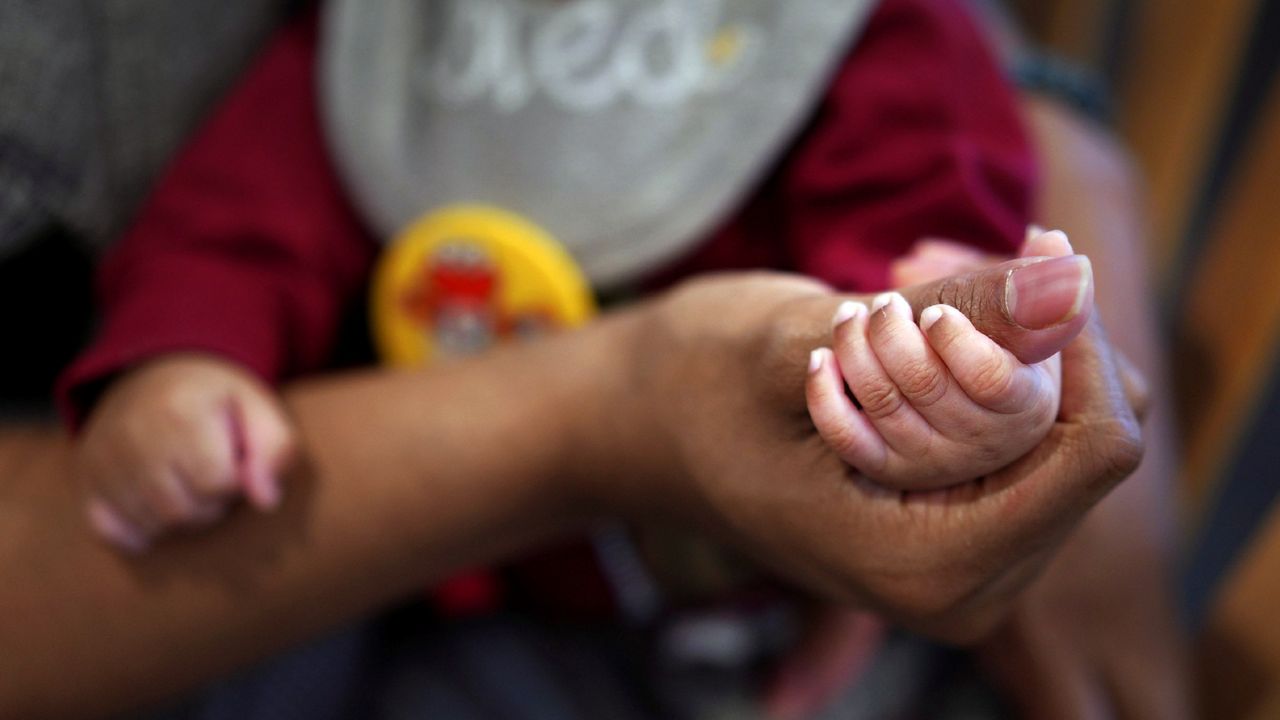 Jasmine Heriot holds her infant's hand on Friday, January 5, 2024, in Fredericksburg, Virginia. (AP Photo/Jessie Wardarski)