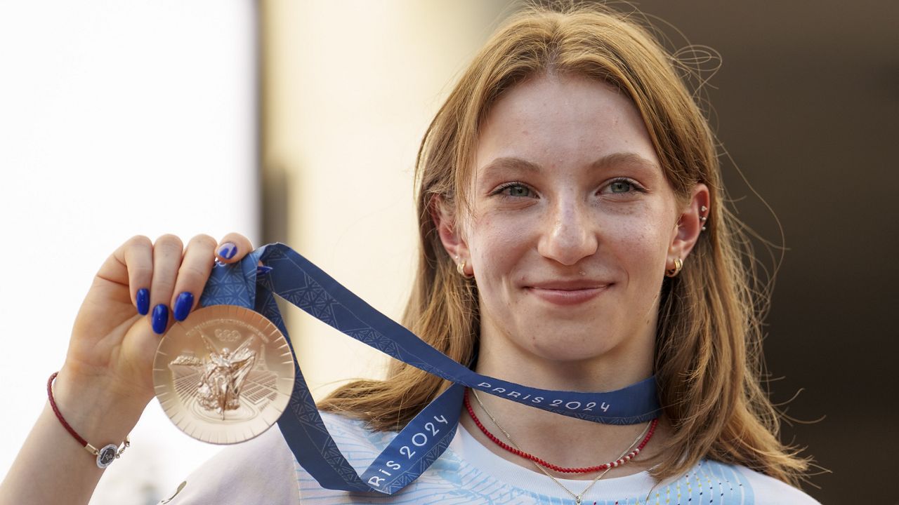 Romanian gymnast Ana Barbosu poses with the bronze medal for her women's artistic gymnastics individual floor performance at the Paris 2024 Olympics, after receiving it during a ceremony at the Romanian Olympic and Sports Committee, in Bucharest, Romania, Friday, Aug. 16, 2024. (AP Photo/Vadim Ghirda)