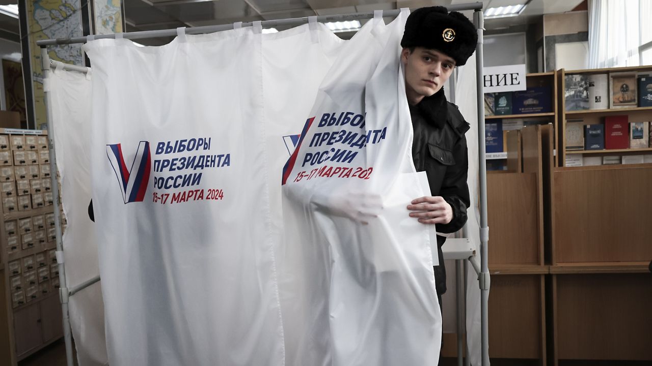 A student of the Maritime State University named after admiral Gennady Nevelskoy leaves a voting booth at a polling station during a presidential election in the Pacific port city of Vladivostok, 3566 miles east of Moscow, Russia, Friday, March 15, 2024.  (AP Photo)