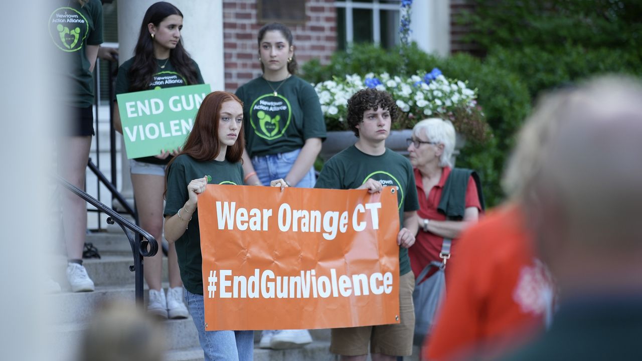 Members of Junior Newtown Action Alliance hold signs during a rally against gun violence on Friday, June 7, 2024 in Newtown, Conn. (AP Photo/Bryan Woolston)