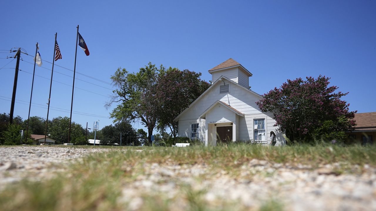 A woman visits the First Baptist Church in Sutherland Springs, Texas, Tuesday, July 2, 2024, which is now a memorial to the 26 people who were killed by a gunman in 2017. The 100-year-old building has served as a memorial since the shooting, but now some want to raze the building. (AP Photo/Eric Gay)