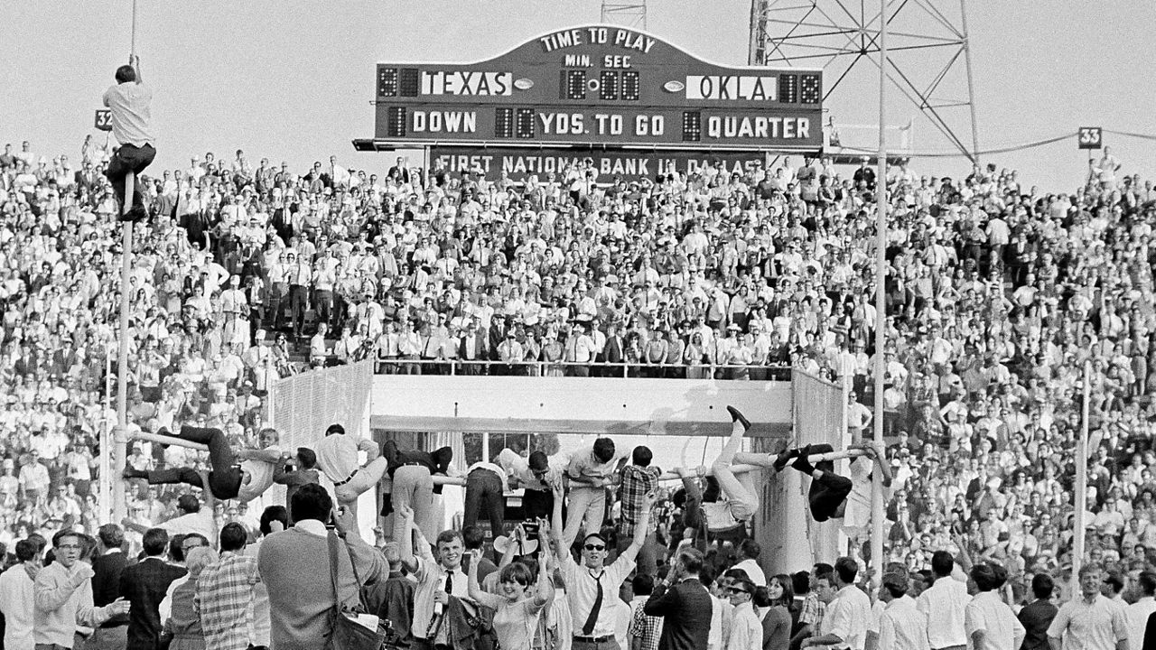 Joyous Oklahoma fans climb the goal posts to tear out the cross bar for souvenirs after the Oklahoma defeated Texas 18-9 in an NCAA college football game at the Cotton Bowl in Dallas, Oct. 8, 1966. The Big 12 is losing its marquee matchup when the Red River Rivalry is played Saturday for the final time under the league’s umbrella.(AP Photo/Ferd Kaufman, File)