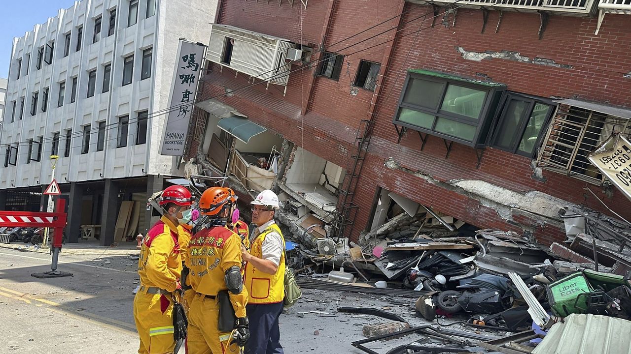 In this photo released by the National Fire Agency, members of a search and rescue team prepare outside a leaning building in the aftermath of an earthquake in Hualien, eastern Taiwan on Wednesday, April 3, 2024. (National Fire Agency via AP)