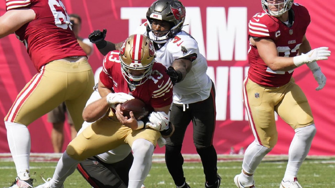 San Francisco 49ers quarterback Brock Purdy (13) is sacked by Tampa Bay Buccaneers defensive tackle Greg Gaines, bottom, as safety Jordan Whitehead (3) follows the play during the first half of an NFL football game in Tampa, Fla., Sunday, Nov. 10, 2024. (AP Photo/Chris O'Meara)